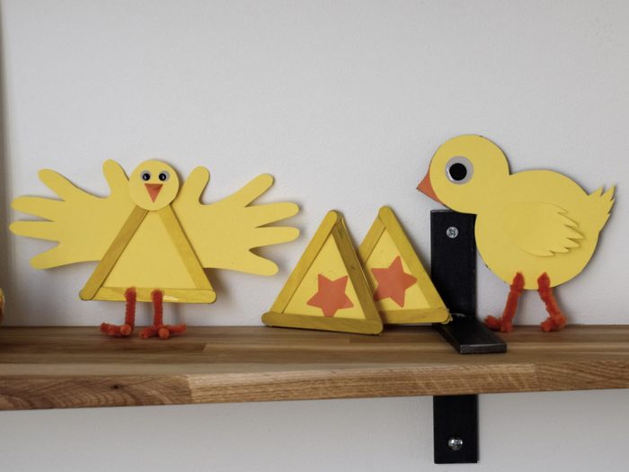Kycklingar tillverkade av gul kartong och glasspinnar